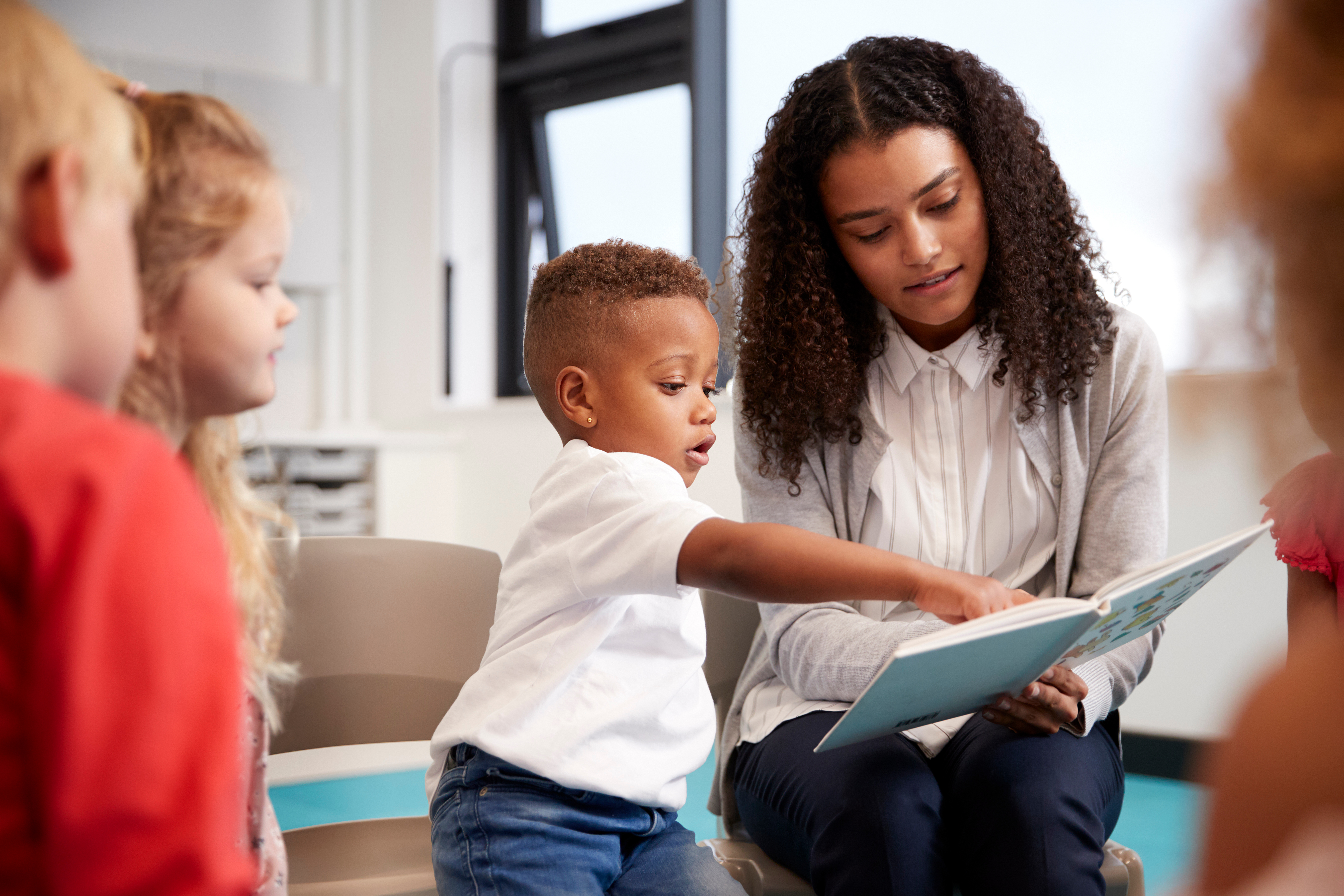 educator and young child reading together