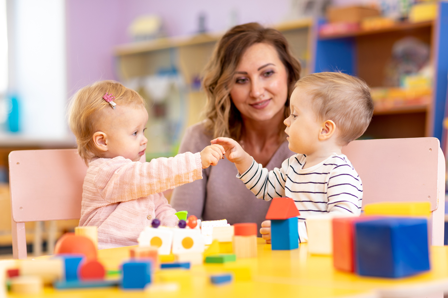 image of two children playing with educator present